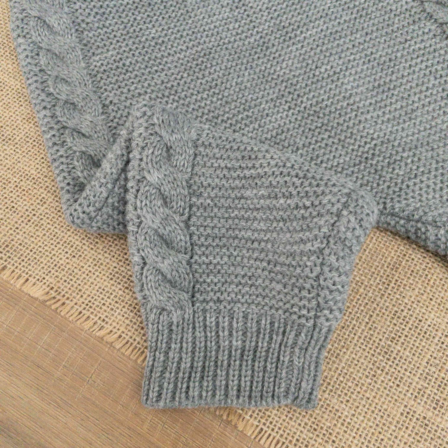 dettaglio lavorazione a maglia pagliaccetto grigio neonato