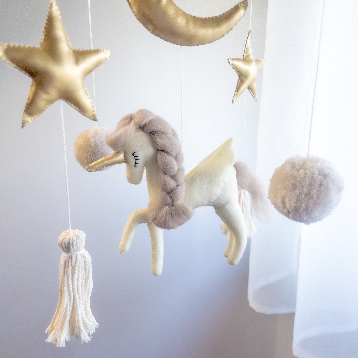 Unicorno, stelle e nuvole in feltro fatte a mano che compongono una giostrina per culla elegante