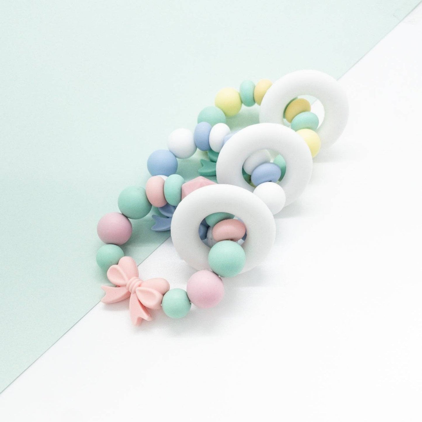 Massaggiagengive ad anello per neonati in silicone rosa e verde menta, design ergonomico ideale per il sollievo durante la dentizione dei bambini