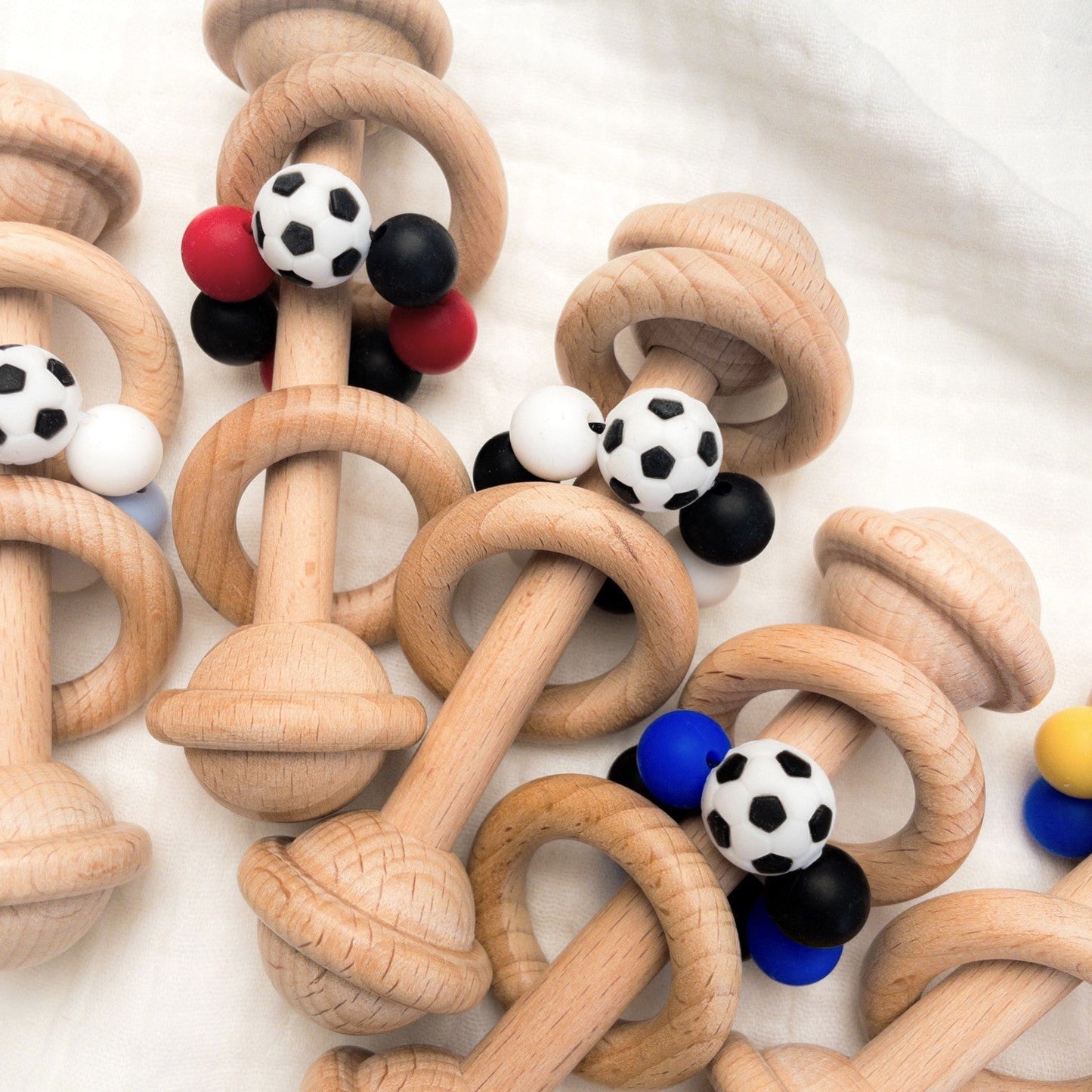 Sonaglio neonato in legno con perline a tema calcio, perfetto come regalo per neo papà tifosi. Personalizzabile con colori della squadra del cuore.