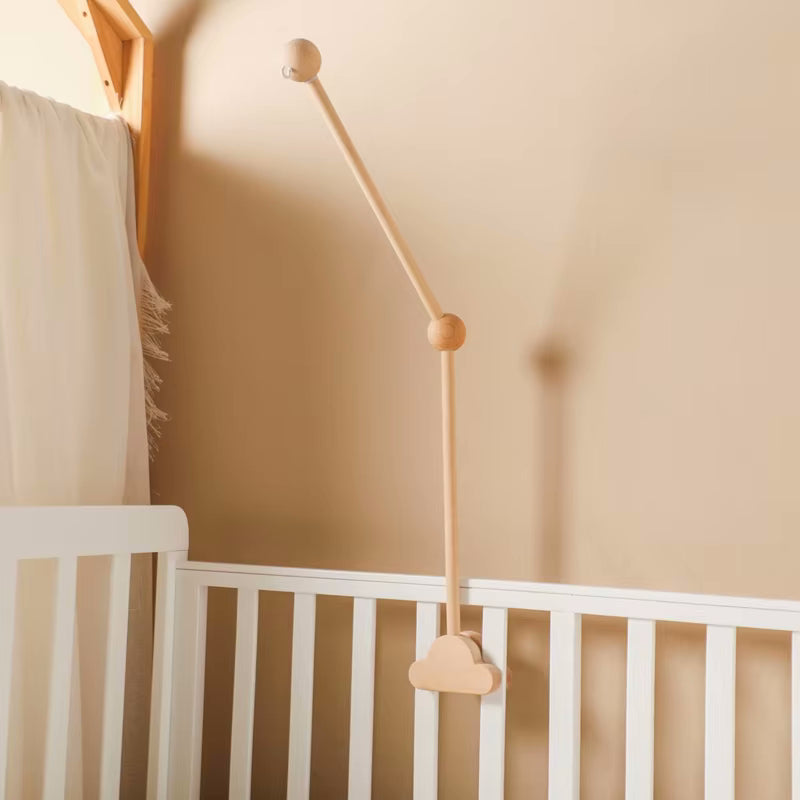 Supporto per giostrina culla Nuvola in legno naturale, montato su una culla bianca. Design elegante e sicuro per appendere giostrine per neonato.
