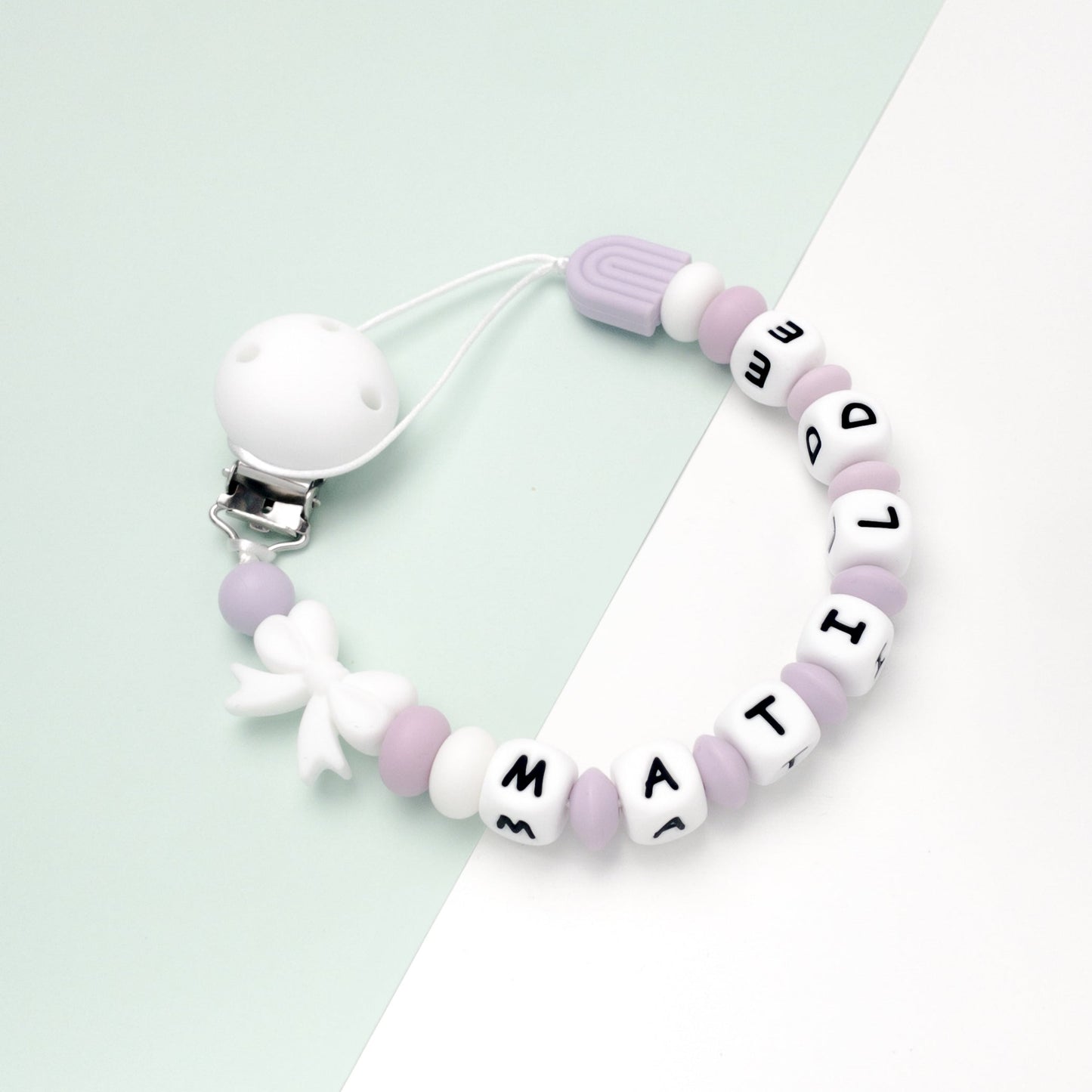 Catenina ciuccio viola e bianco con nome Matilde con fiocco e arcobaleno viola in silicone