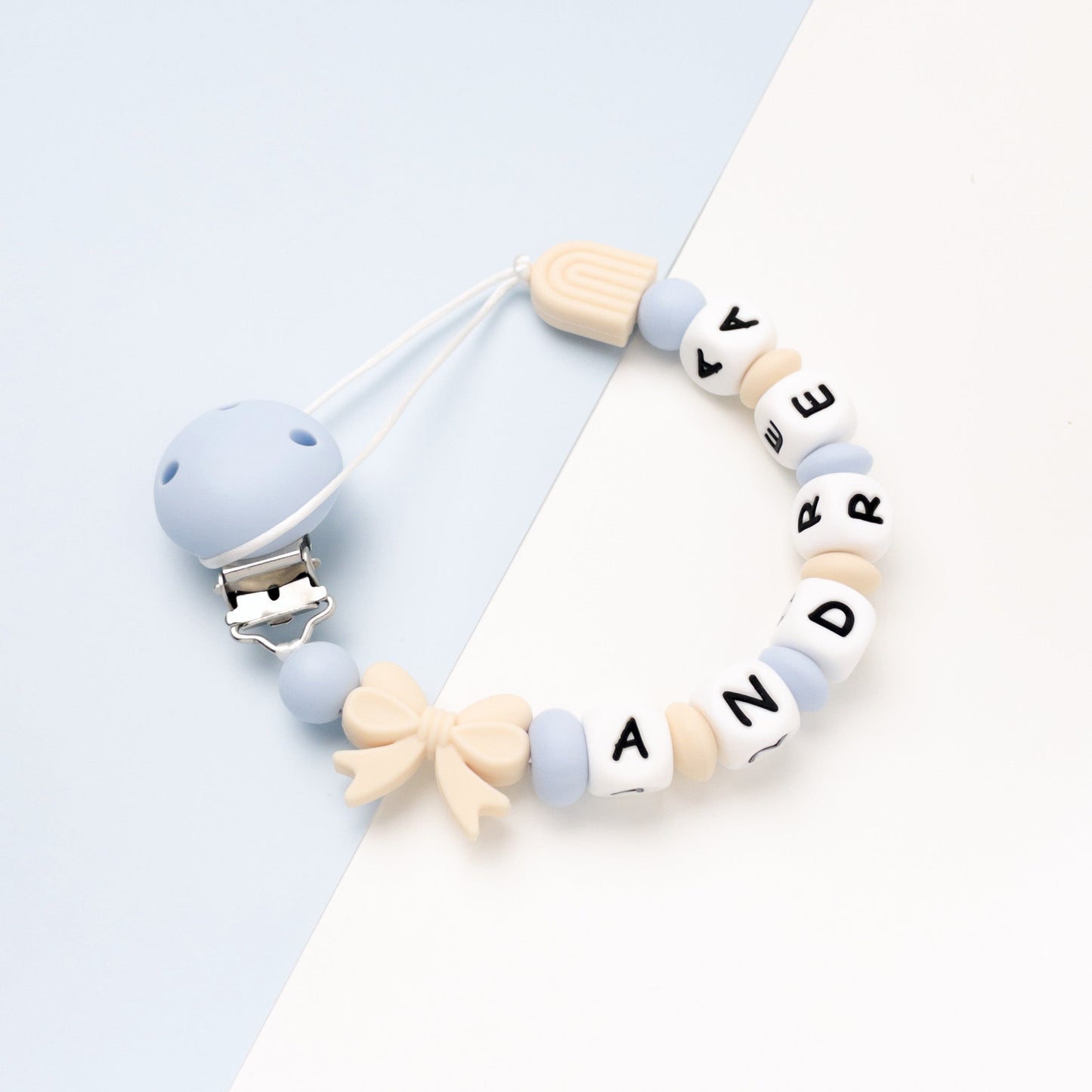 Catenina porta ciuccio con nome azzurro e beige con fiocco e arcobaleno in silicone con nome Andrea lettere in silicone