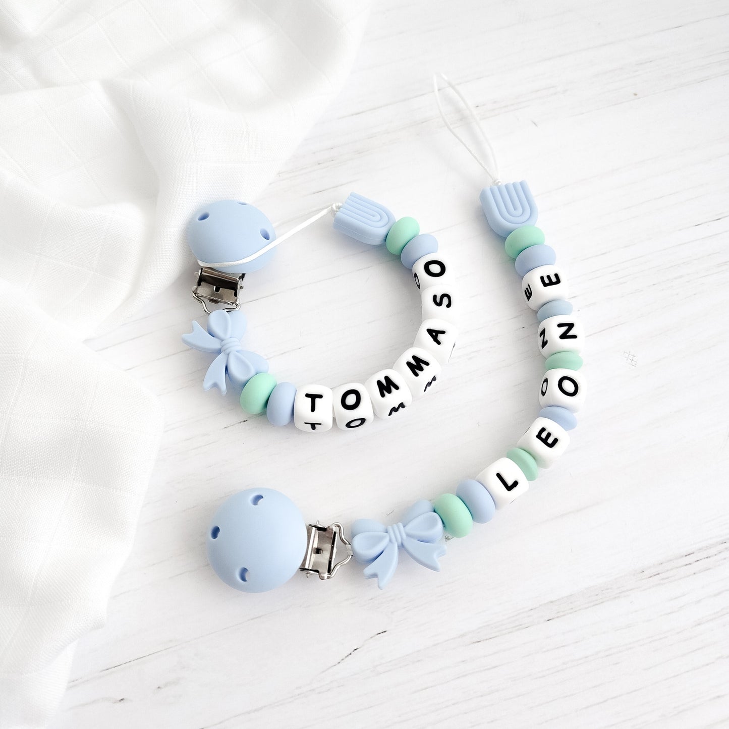 Catenella ciuccio personalizzata con nome LEONE in silicone azzurro e verde, ideale come regalo nuova nascita Baby Island.
