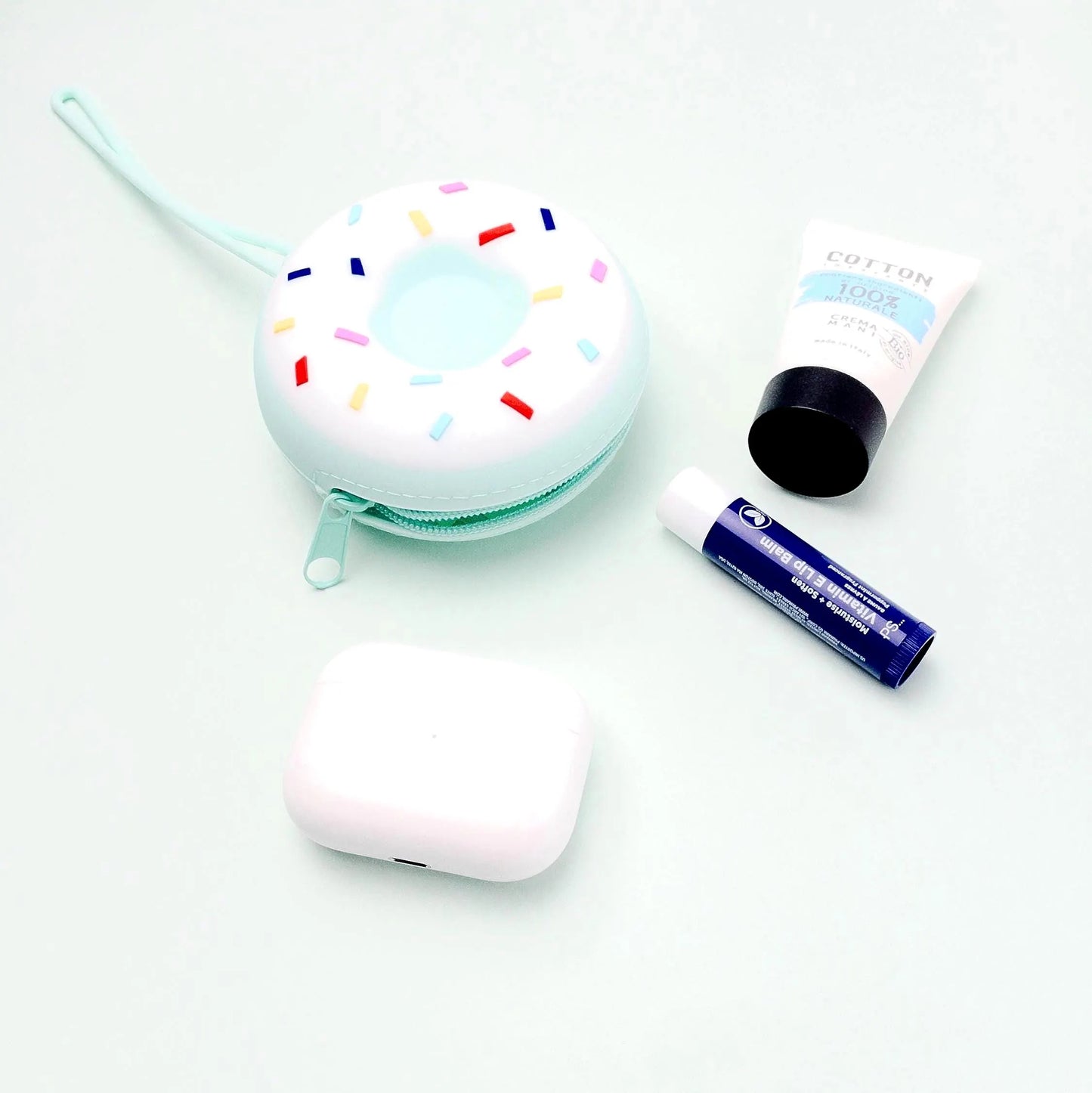 Custodia silicone per ciuccio a forma di donut in colori bianco e verde tiffany con cerniera, si può vedere dentro il ciuccio e un pezzo di catenina porta ciuccio che esce.