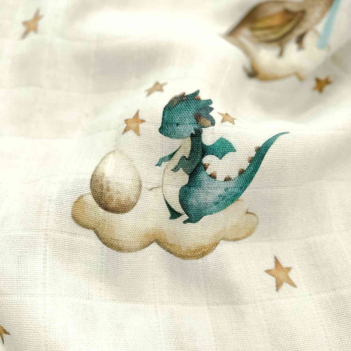 Dettaglio ravvicinato della trama leggera e quadrettata della mussola, che mostra il motivo di un draghetto addormentato su una nuvola.