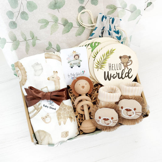 Original and unique baby gift set for baby boy safari themed with baby milestones, muslin blanket, cute socks with lion and wooden rattle lion shaped. Is possible to add gift box and personalized message for new parents.