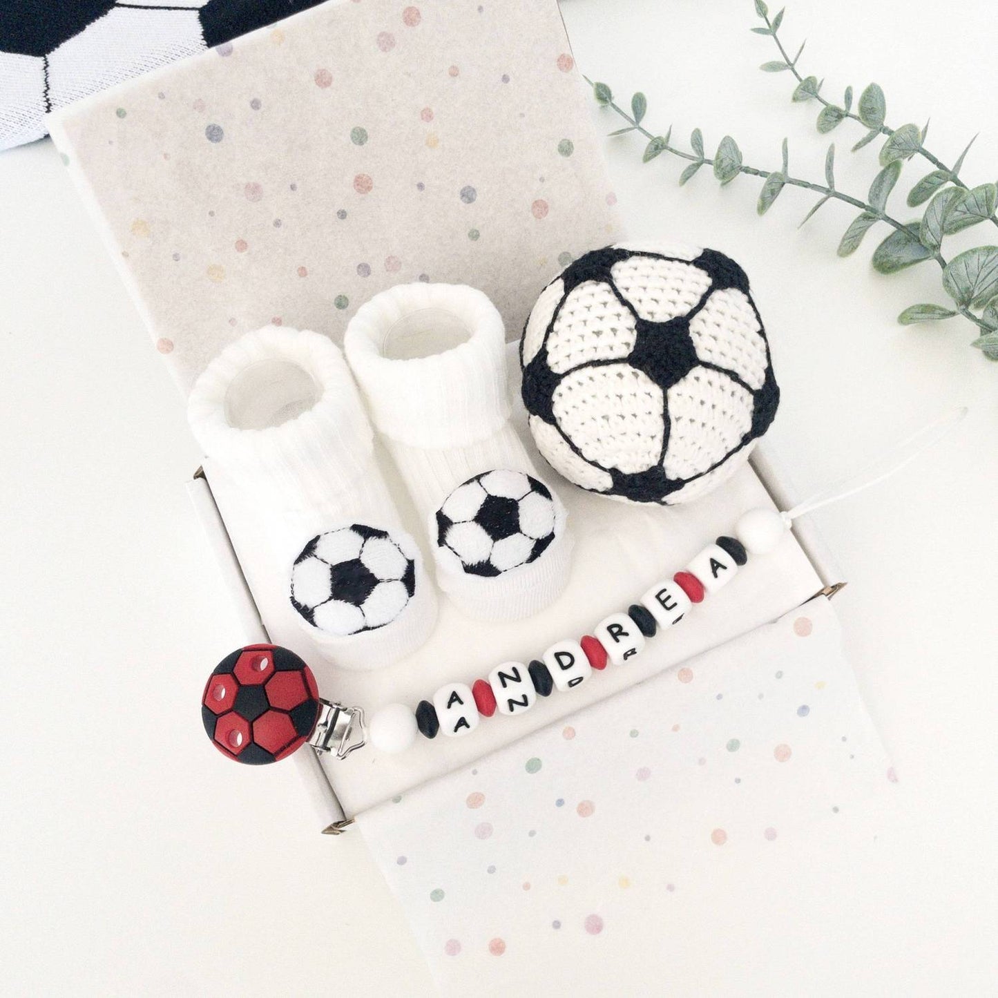 Set regalo neonato tema calcio con palla calcio amigurumi con campanellino, calzini bianchi decorati e catenella ciuccio personalizzata.