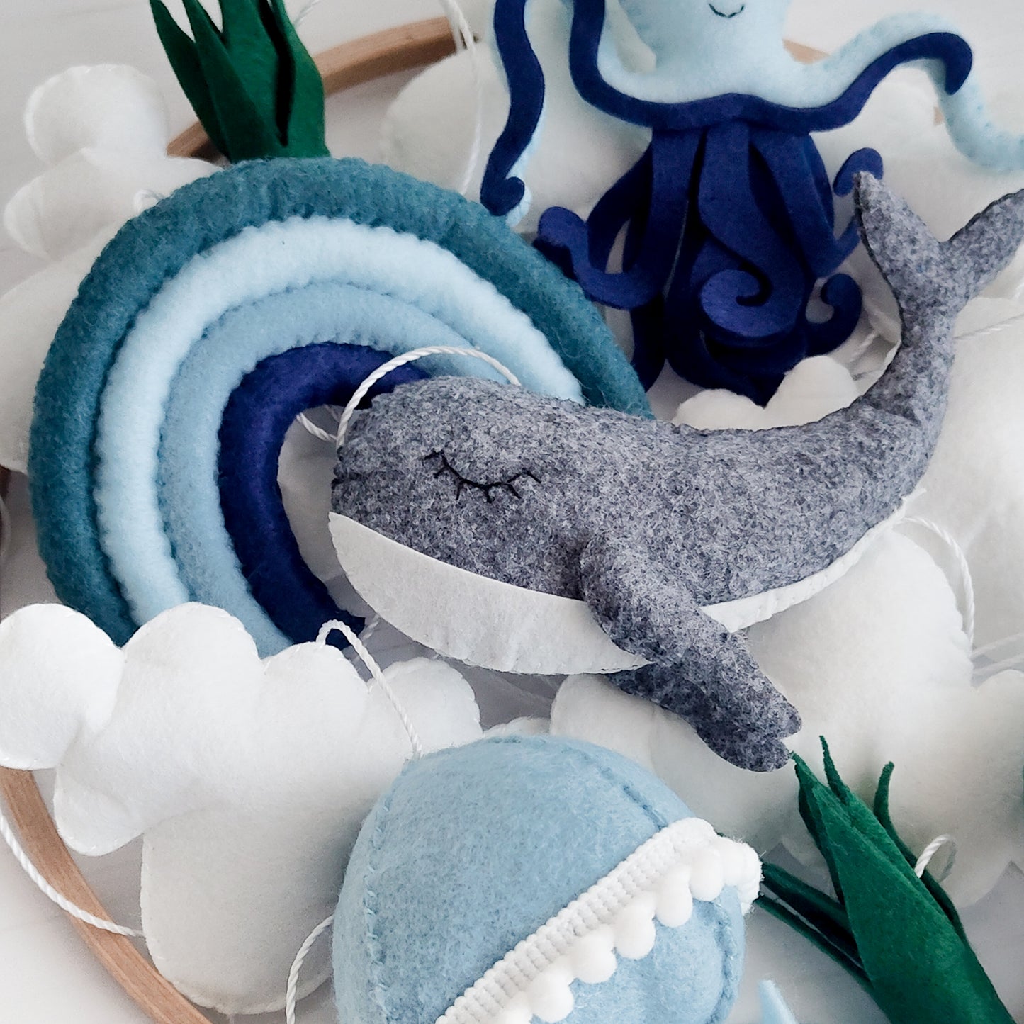 Decorazione neutra unisex per cameretta neonato ispirata all'oceano. Toni pastello e scuri mixati di blu, azzurro polvere e verde menta. Adatta sia per maschietti che per femminucce, ideale per genitori che amano lo stile montessoriano e minimalista