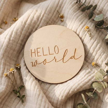 Dettaglio della card in legno Hello World con decorazioni di foglie e tessuto morbido