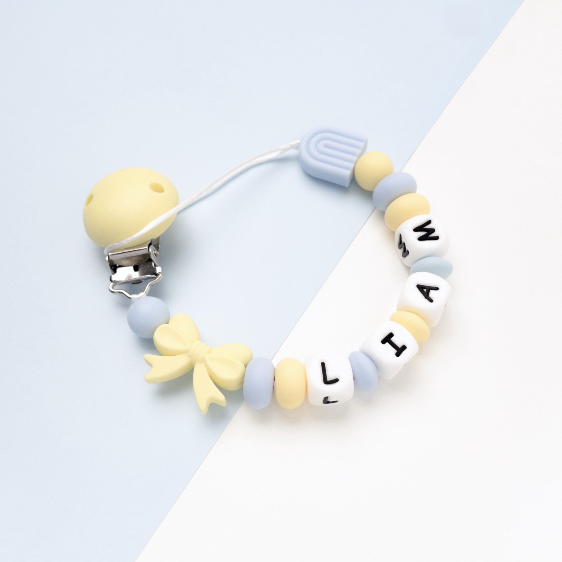 Catenina portaciuccio con nome giallo azzurro con fiocco nome Liam con fiocco e arcobaleno in silicone