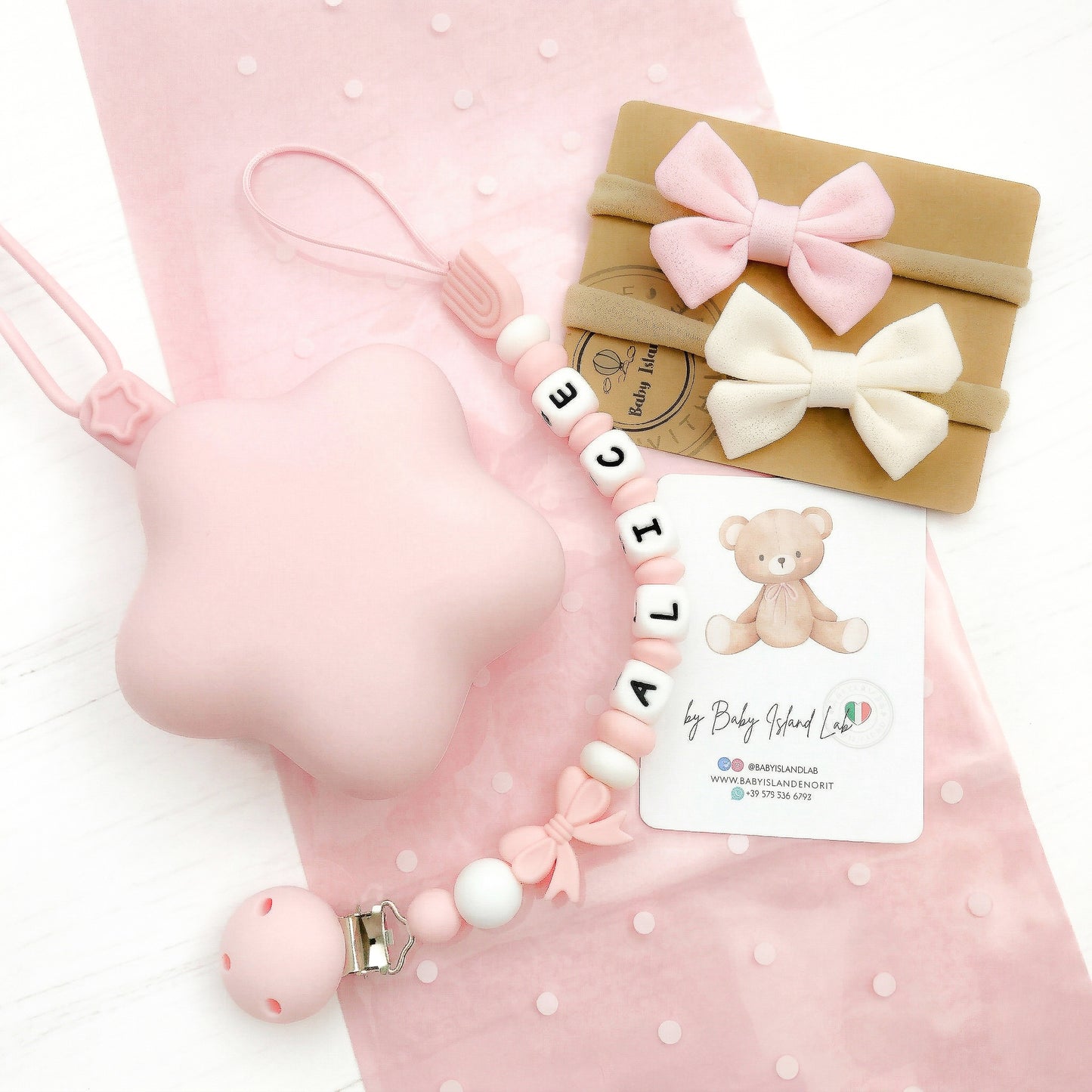Set regalo neonata paersonalizzato con catenella porta ciuccio con nome E perline a forma di fiocco e arboleno, custodia a forma di stella bianca in siliocne e 2 fasce per neonata con fiocco a farfalla.