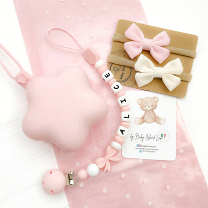 Set regalo neonata paersonalizzato con catenella porta ciuccio con nome E perline a forma di fiocco e arboleno, custodia a forma di stella bianca in siliocne e 2 fasce per neonata con fiocco a farfalla.