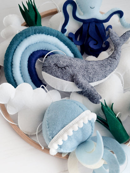 Decorazione neutra unisex per cameretta neonato ispirata all'oceano. Toni pastello e scuri mixati di blu, azzurro polvere e verde menta. Adatta sia per maschietti che per femminucce, ideale per genitori che amano lo stile montessoriano e minimalista