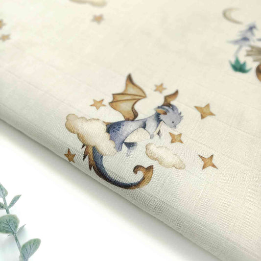 Mussola con fantasia di draghetti, avvolta in modo da mostrare la morbidezza del tessuto e la ripetizione del motivo