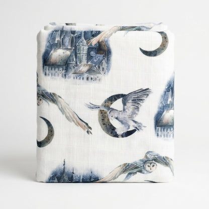 Musola neonato in cotone e bambù con fantasia fiabesca blu su bianco, forma avvolgente e leggera, ideale per fasciatura e allattamento