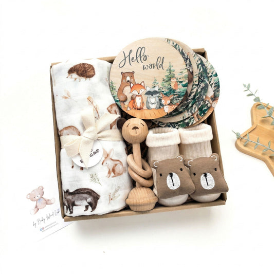 Set regalo neonato maschio femmina Woodland Adventures, con accessori a tema animali foresta: mussola 120x120, milestone card legno, sonaglio orsetto, calzini orsetto. Regalo nascita baby shower originale e utile, confezionato in scatola con fiocco. Kit neonato unisex per prime foto, cura quotidiana e ricordo crescita. Regalo neogenitori per bambini appena nati