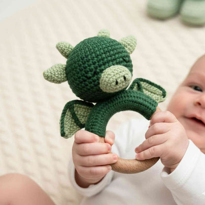 Bambino che gioca con sonaglino drago verde del set regalo neonato draghi con mussola e complimese | Baby Island.