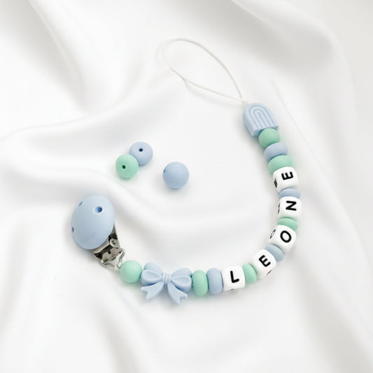 Catenella ciuccio personalizzata con nome LEONE in silicone azzurro e verde, ideale come regalo nuova nascita Baby Island.